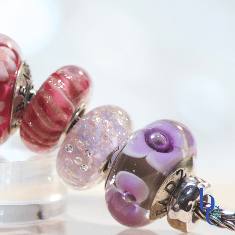 Image of an fun ombre European bracelet design by BijouxChat.com that features an assortment of Elfbeads and TrueBeadz beautifully colored beads  arranged on a light grey backdrop.