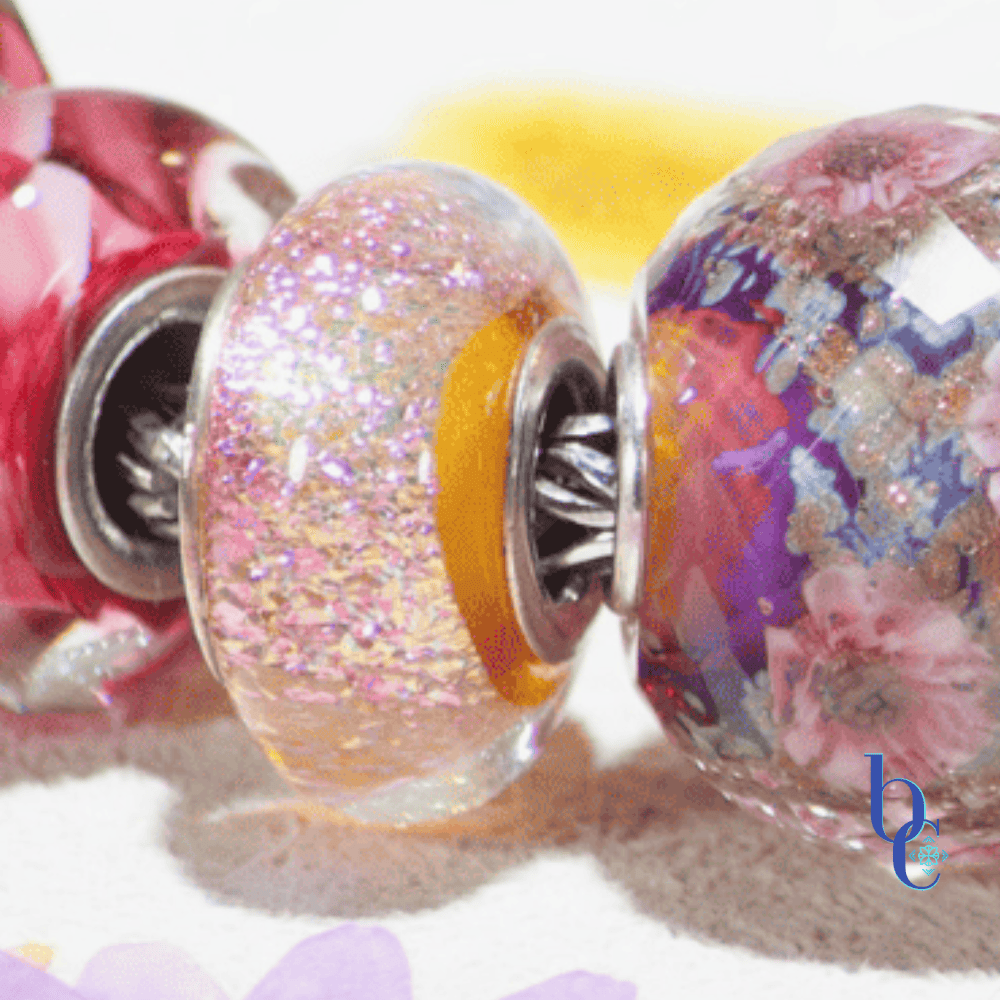 Bijoux Chat's Magnetic Magenta Bracelet Design Featuring a Chamilia Peachy Pink Radiance Bead with Orange Edges next to the Elfbeads Cherry Blossom Shimmering World Fractall Bead Macro