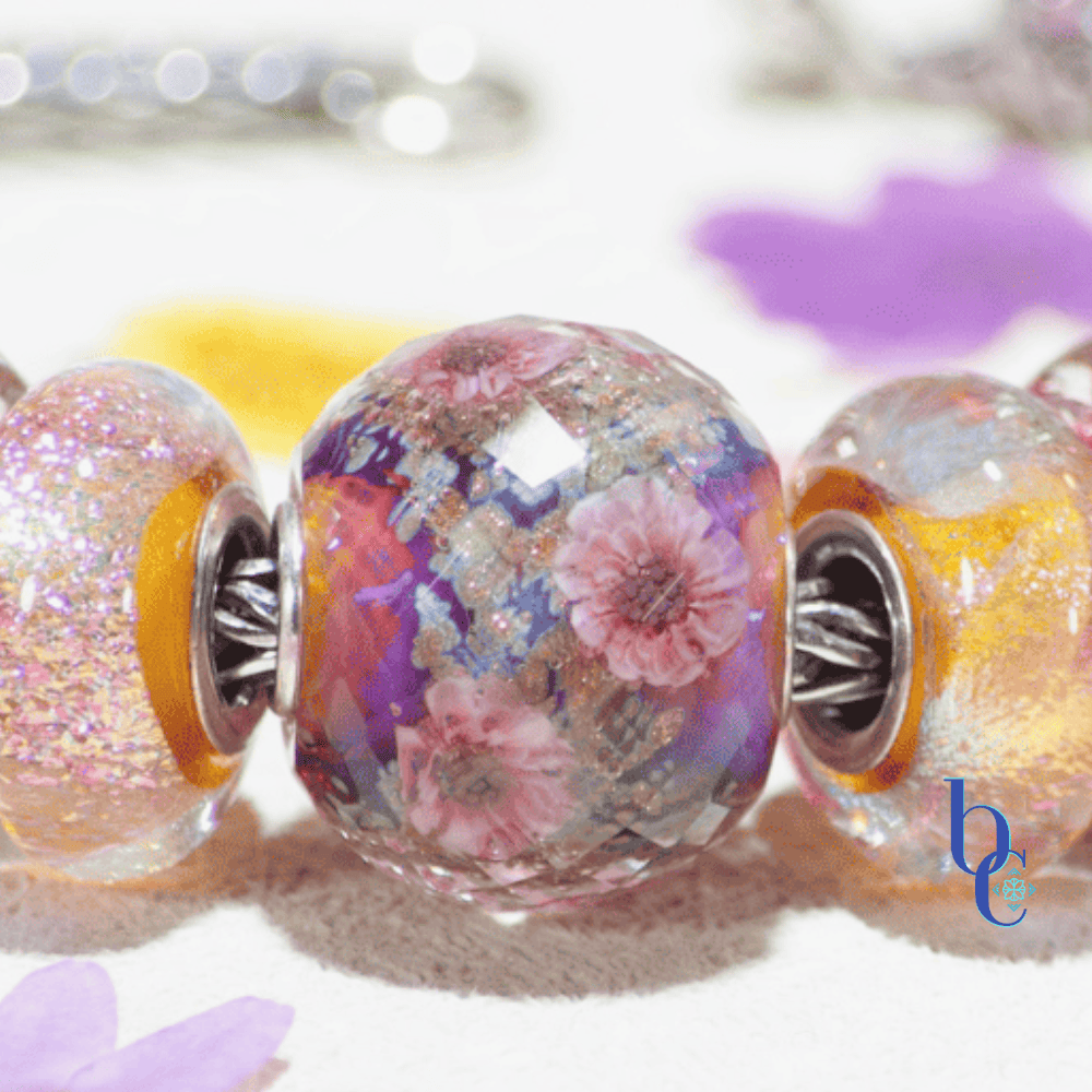 Close up detail of the Elfbeads Cherry Blossom Fractal glass bead showing internal facets and shimmering magenta particles.