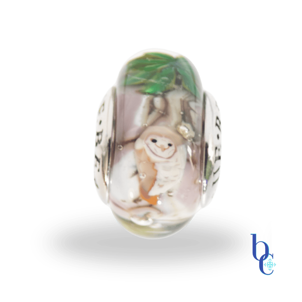 A OOAK artisan made bead by Alexey Ivanov (silversmith) and Julia Trubitsyna (glass artist) of TrueBeadz that features a tiny owl in a snowy forest, all captured in a miniature European glass bead charm.
