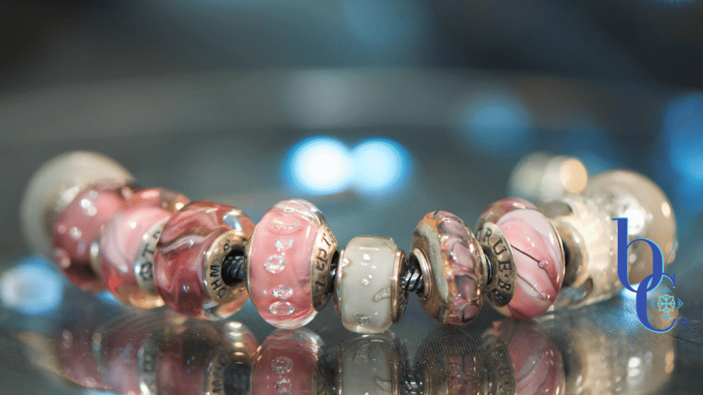 A luxury full-chain European charm bracelet layout featuring matte gray concrete beads, translucent smoky purple glass, and a sparkling pink lilac crystal charm centered on a sterling silver chain. Description: A high-contrast studio macro photograph capturing the rich textural transitions from industrial matte surfaces to shimmering glass facets, emphasizing the butterfly wing motif of the central charm.