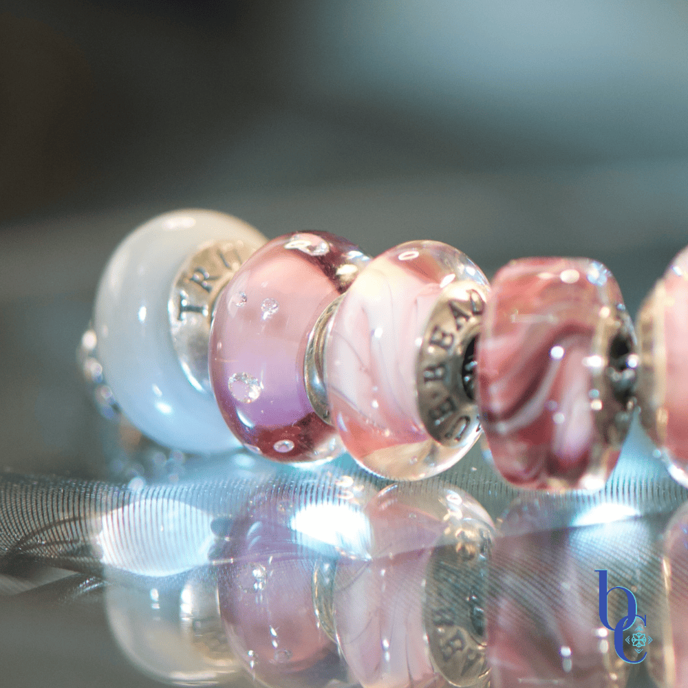 A high-contrast studio macro photograph capturing the rich textural transitions from industrial matte surfaces to shimmering glass facets, emphasizing the cz accents and swirling colors of the charms.
