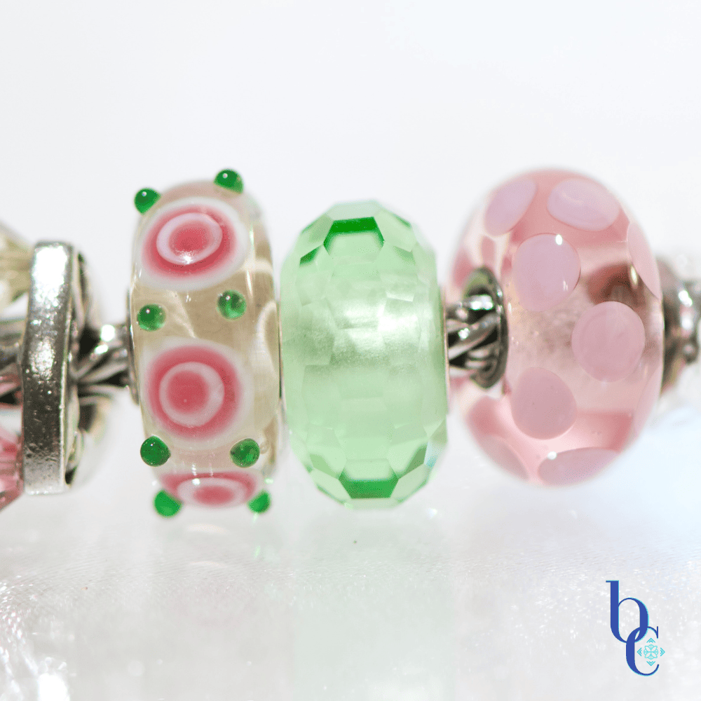Extreme close-up of  artisan glass beads showing their details and color flanked by various beads in the design.