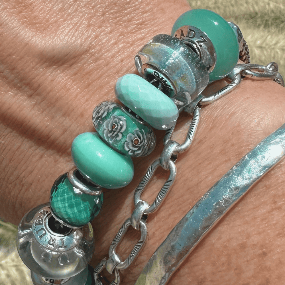 The Cerulean Shift bracelet worn in bright, natural sunlight on a woman's wrist.