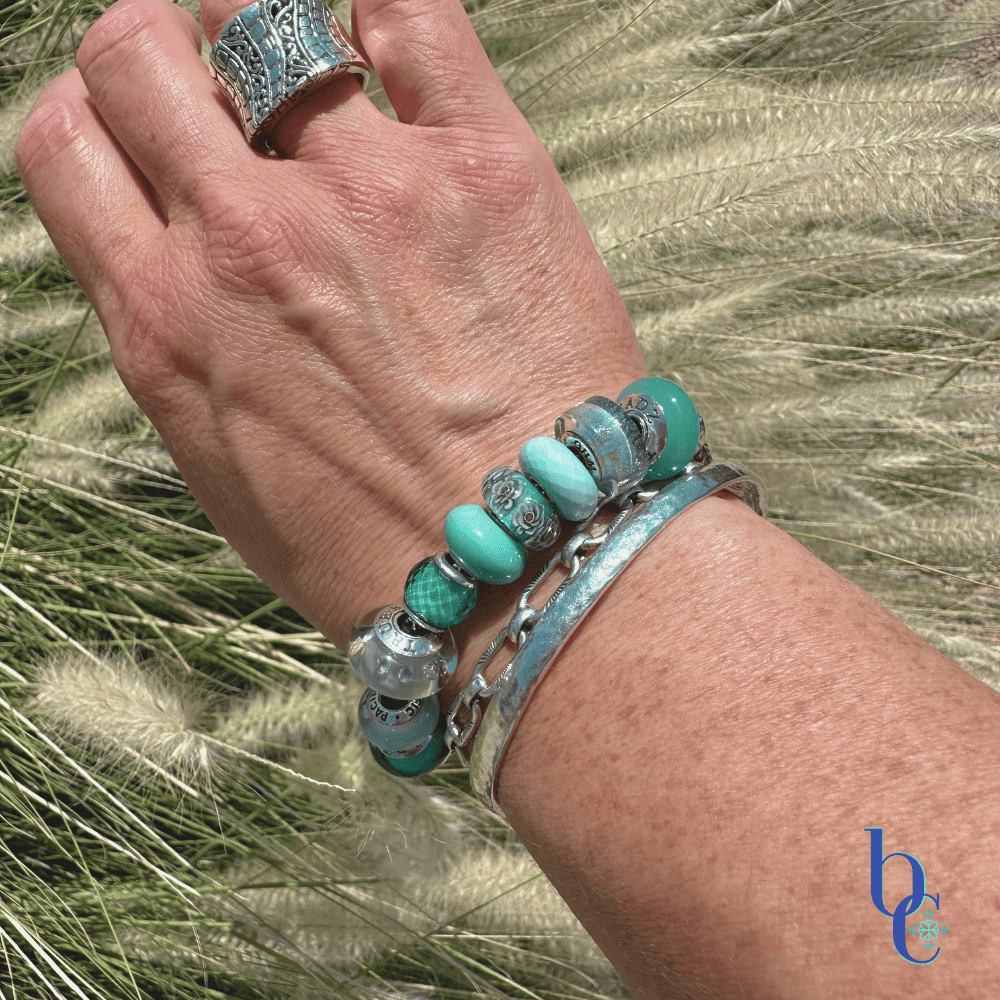The Cerulean Shift bracelet worn in bright, natural sunlight on a woman's wrist.