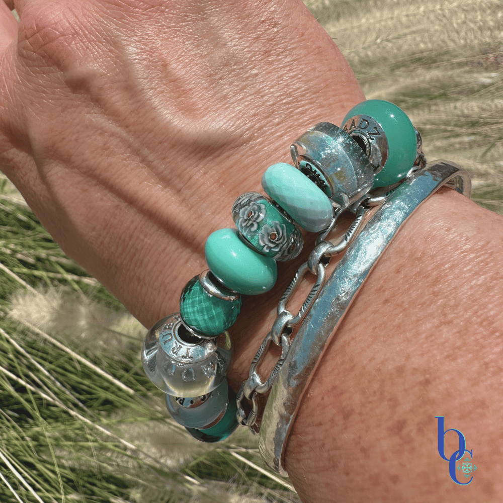 The Cerulean Shift bracelet worn in bright, natural sunlight on a woman's wrist.