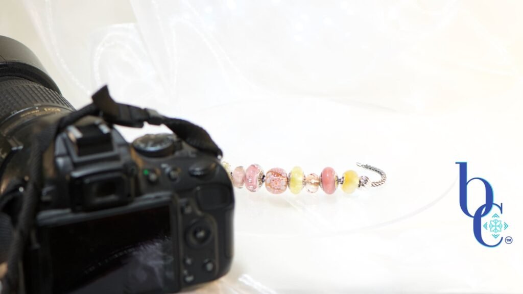 Discover the real photography and creative process behind Bijoux Chat. Learn how the CharmStack© Visualizer ensures authentic European charm bracelet designs. An image of the simple studio setup to photograph the blog's designs.